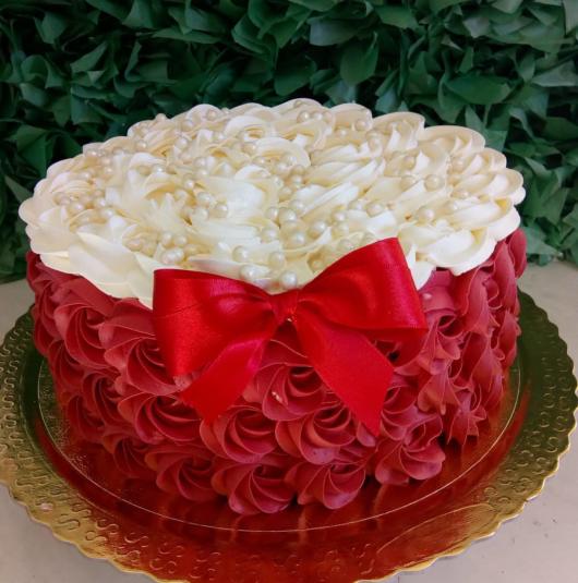 bolo decorado com chantilly vermelho e branco