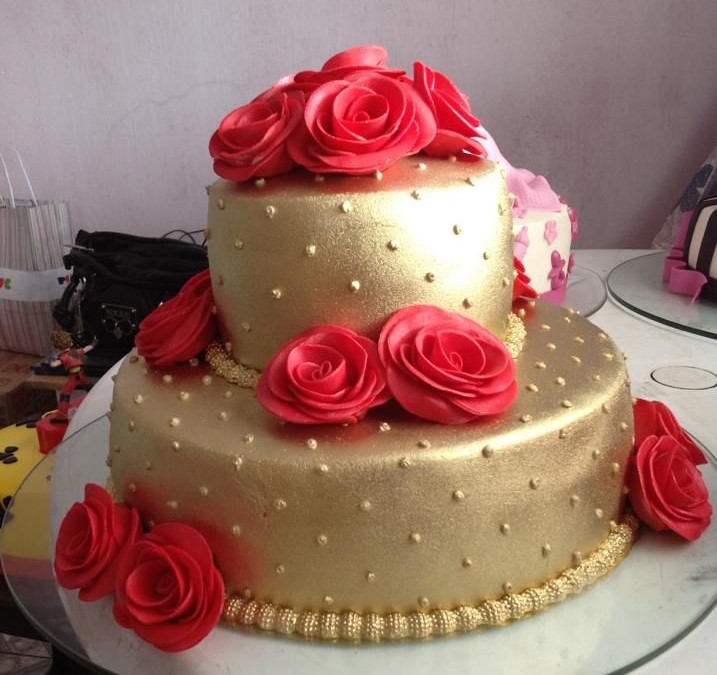 bolo dourado com rosas vermelhas