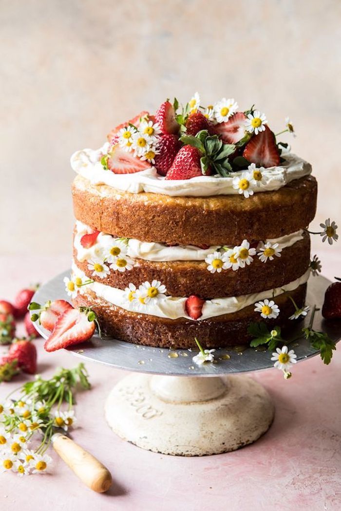 Bolo de aniversário coberto com frutas vermelhas e gotas de chocolate na  toalha de mesa branca conceito moderno de padaria