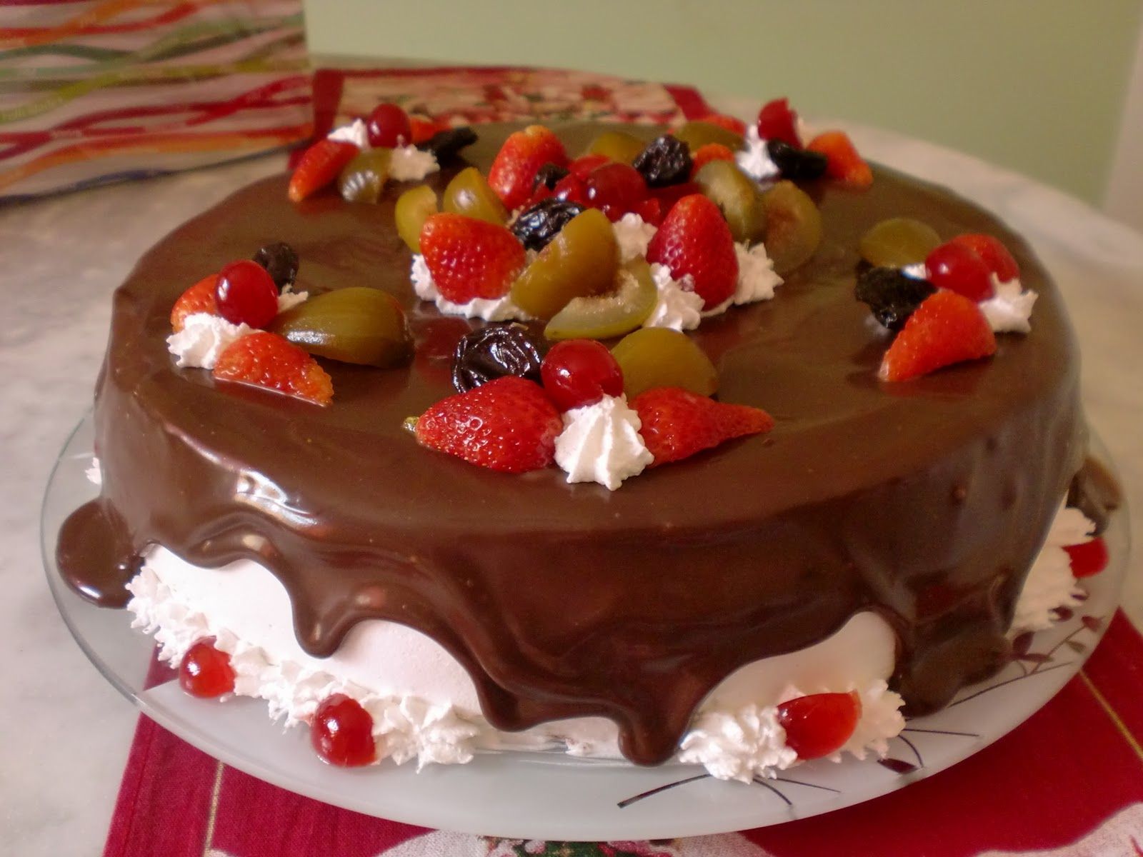 Bolo de aniversário coberto com frutas vermelhas e gotas de chocolate na  toalha de mesa branca conceito moderno de padaria