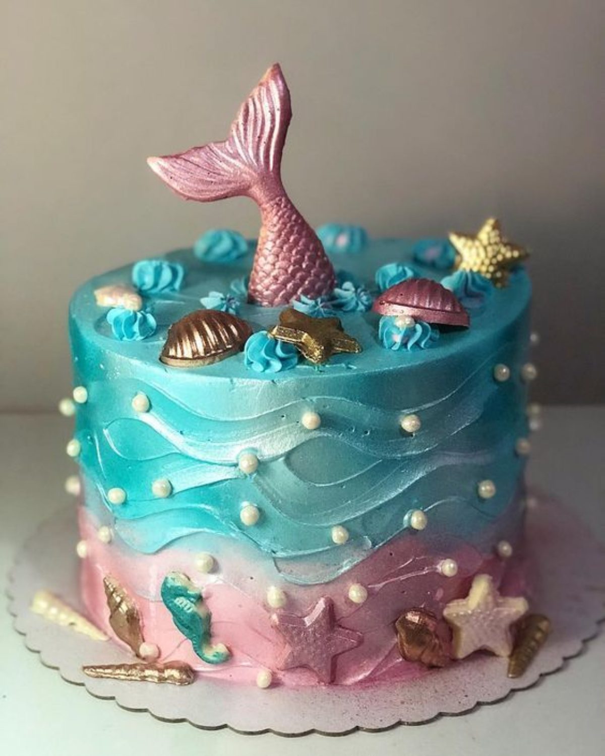 Bolo de aniversário com sereias em um fundo roxo